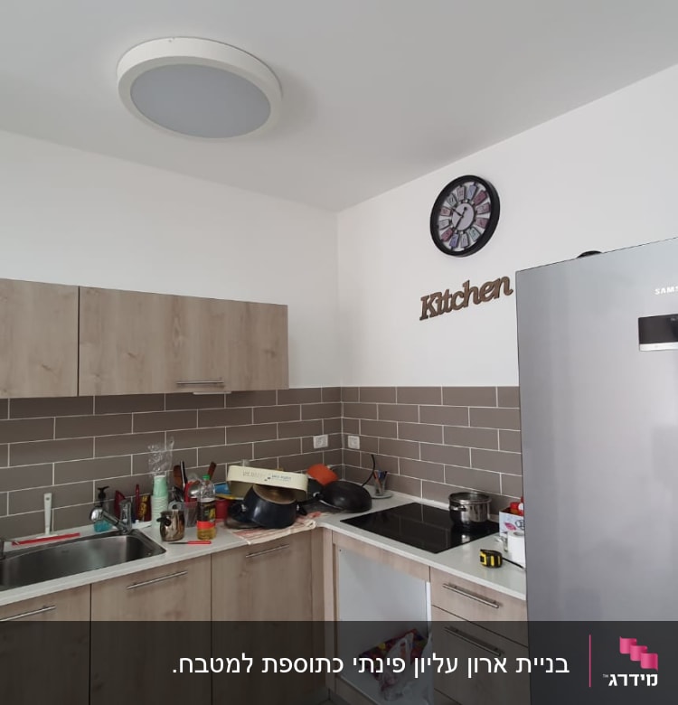 מטבח עם ארונות עץ, כיור ותנור